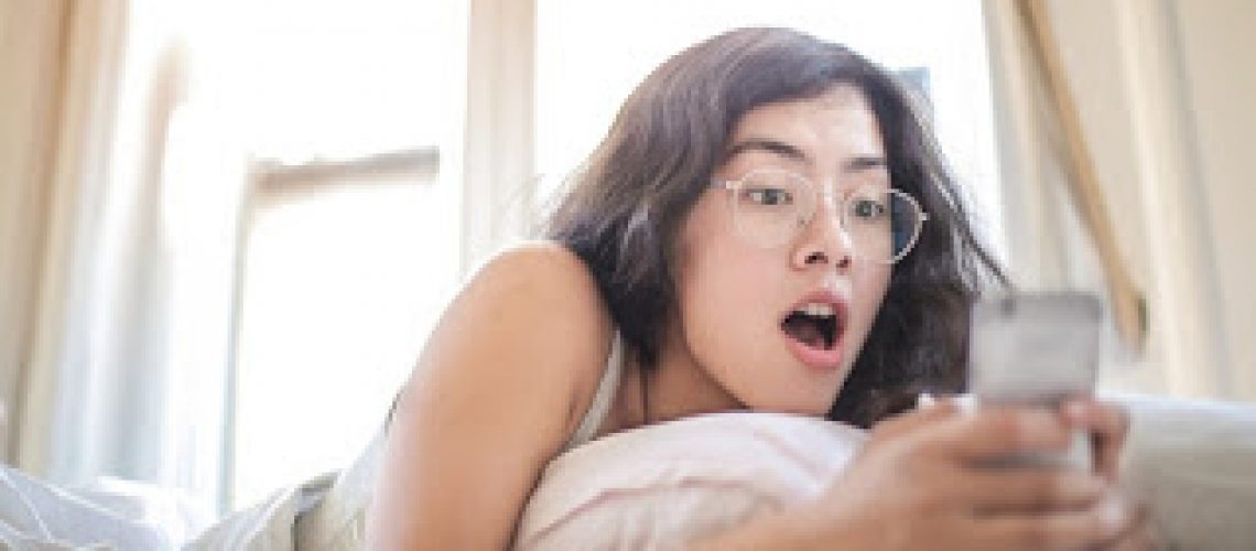 woman-lying-on-bed-holding-smartphone-3807535.jpg